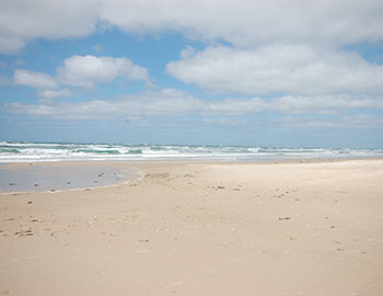 Breiter Sandstrand mit blauem Himmel und der Nordsee