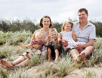 Niedliche Familie sitzt in den Dünen bei Grönhöj Strand