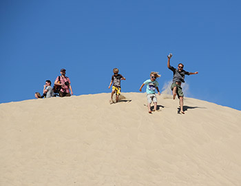 Familie mit Kindern spielt im Sand bei Rubjerg Knude Fyr